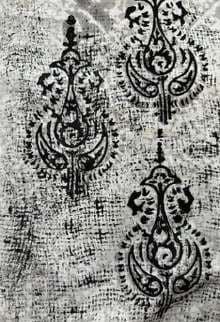 Black paisley block prints over a mottled grey ground.