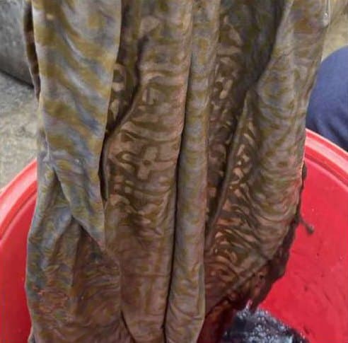 Fabric with a wavy resisted pattern lifted from a red tub.