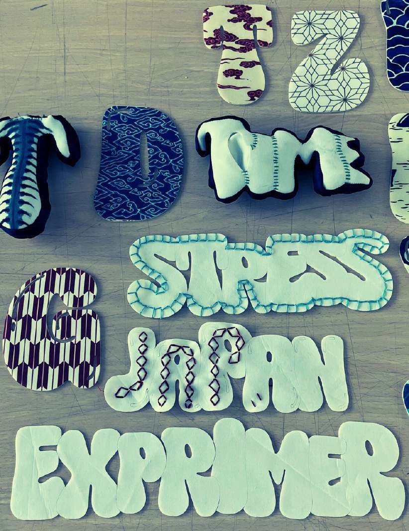 Printed and tie-dyed fabric letters spelling words like TIME, STRESS, JAPAN and EXPRIMER.