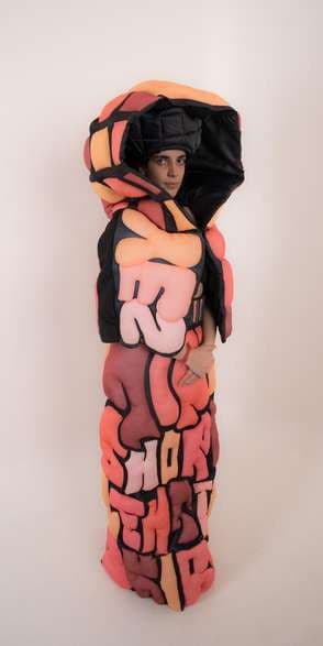 The coral cape closed into a column of puffed letters.