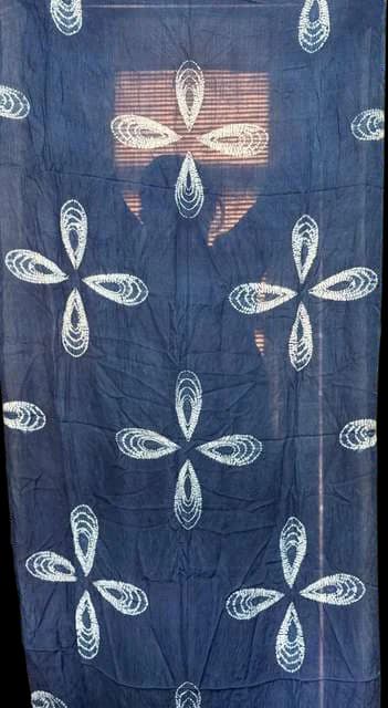 Indigo cloth with pale four-petal resist flowers.