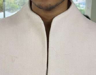 Close-up of a clean stand collar in cream fabric.