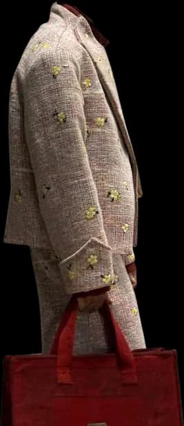 A textured two-piece built from the re-woven material, dotted with small embroidered flowers, carrying a red bag.