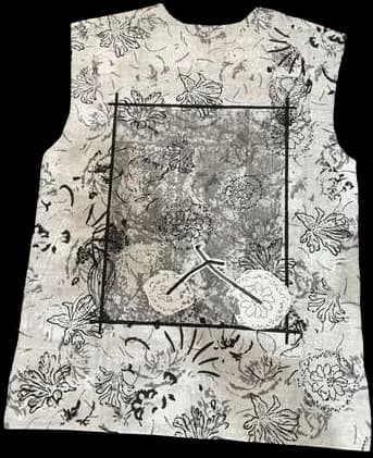 A vest panel with a framed block-printed scene sprayed over in grey.